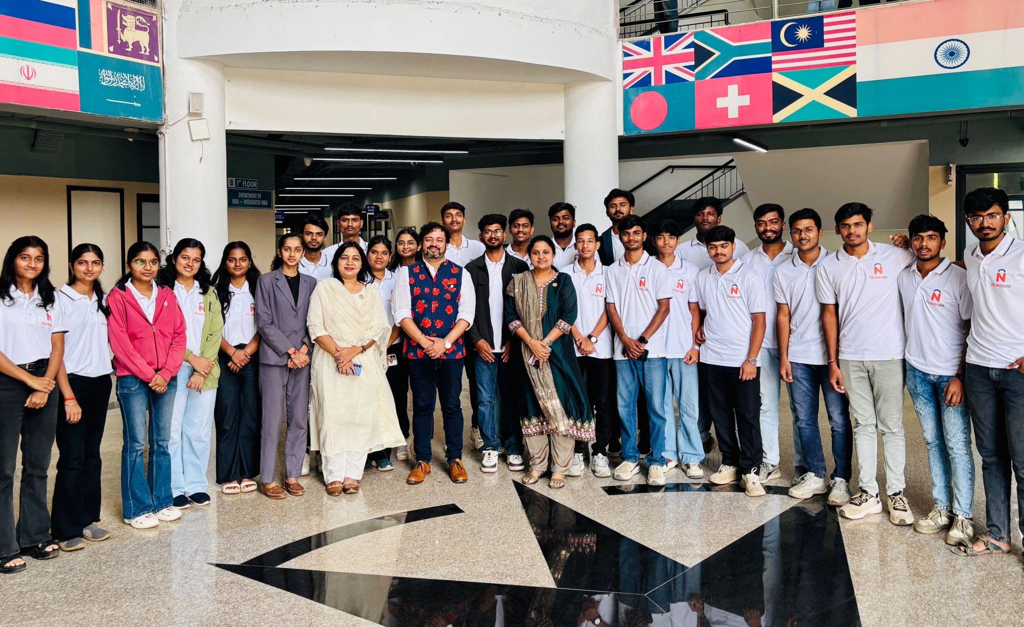 The Nukaazo team in branded T-shirts with mentors, gathered in a college atrium